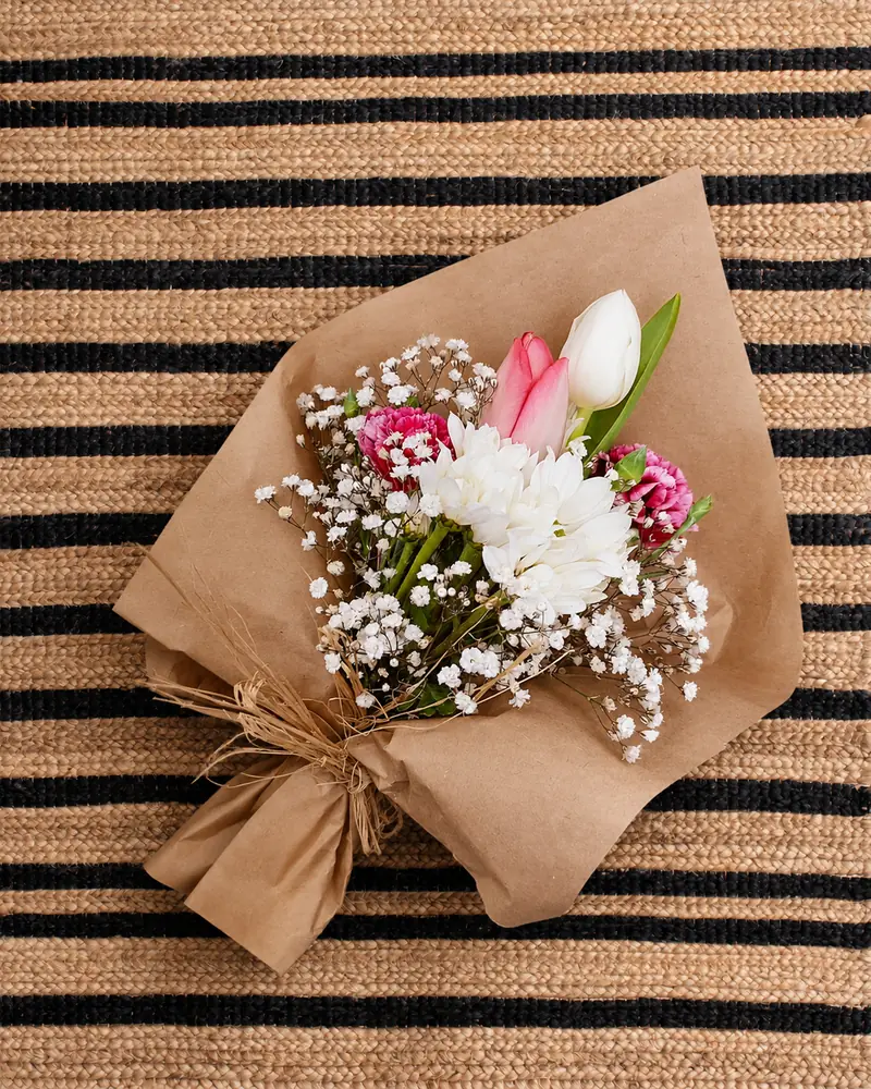 Example with sample flowers: a wrapped bouquet in the Jute rug · from above room, kept as made