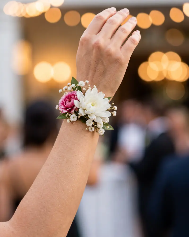 Example with sample flowers: a wrapped bouquet in the Wrist · golden bokeh room, made into a corsage
