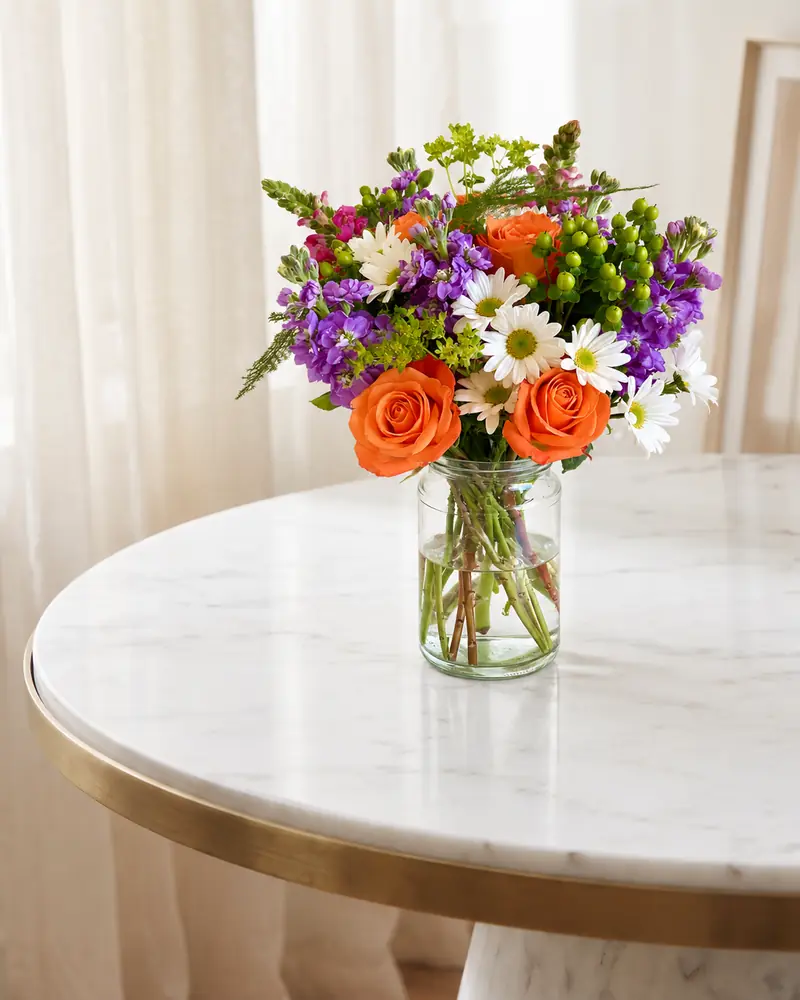 Example with sample flowers: a vase arrangement in the Marble table · sheer curtains room, kept as made